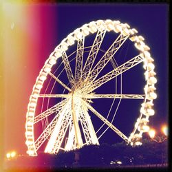 Low angle view of illuminated ferris wheel at night