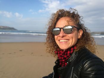 Portrait of smiling woman wearing sunglasses at beach