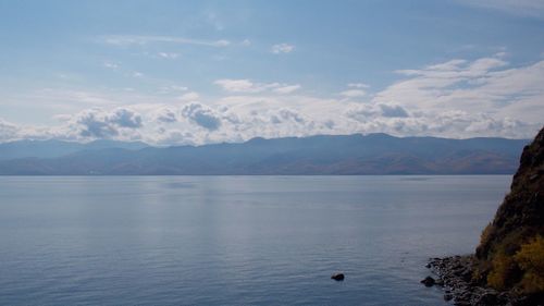 Scenic view of sea and mountains against sky