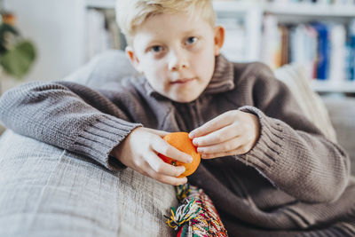 Boy peeling clementine