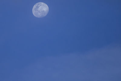 Low angle view of moon against blue sky at night