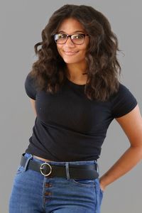 Portrait of smiling woman standing against gray background