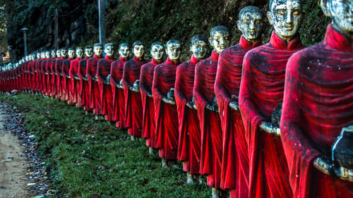 Old buddha statues on grassy field