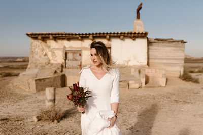 Woman standing by stone wall