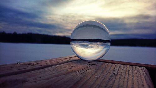 Close-up of water in lake against sky during sunset