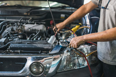 Midsection of man repairing car