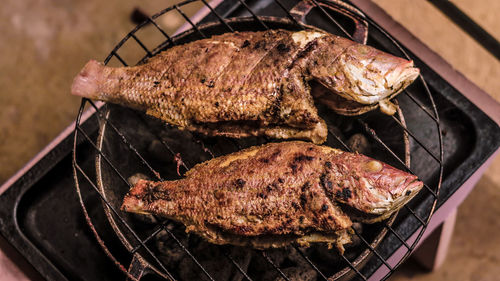 High angle view of fish on barbecue grill