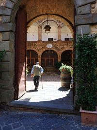 Rear view of man walking towards house