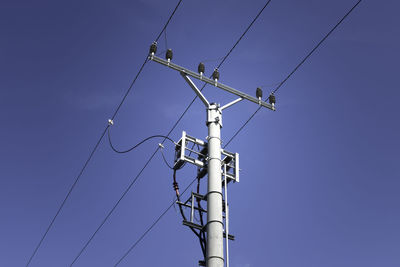 Low angle view of electricity pylon against sky