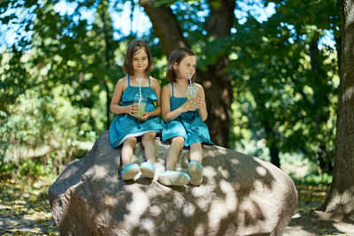 Two little girls drinking lemonade in park