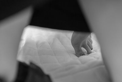 Close-up of hands on bed