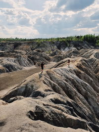 People on rock formations against sky