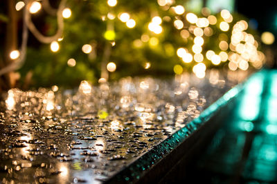 Close-up of wet illuminated street during rainy season