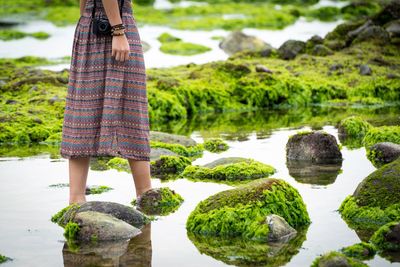 Low section of woman walking in shallow water