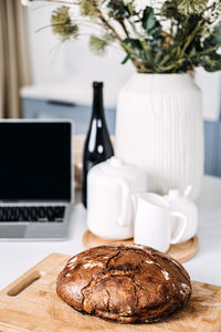 Homemade bread on kitchen table with laptop. freshly baked homemade bread on a cutting board 