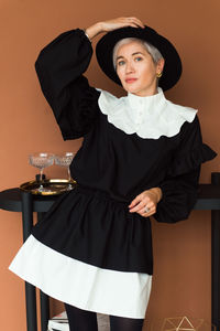 Fashion woman in vintage black and white dress wearing hat looking at camera