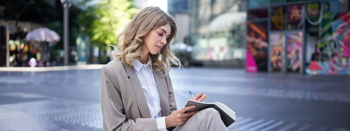 Young woman using mobile phone in city