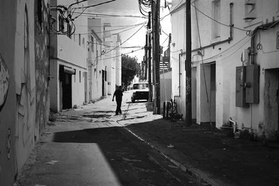 Man walking on street amidst buildings in city