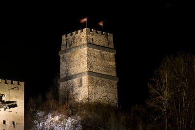 Low angle view of illuminated castle against sky at night