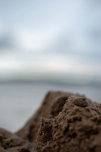 Close-up of rocks on beach against sky