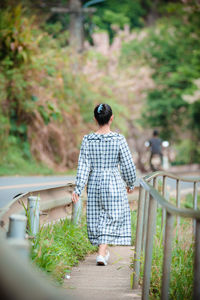 Rear view of man standing by railing