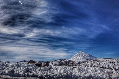 Scenic view of volcanic mountain against blue sky