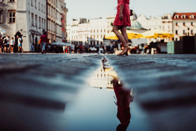 Low section of woman walking on city street