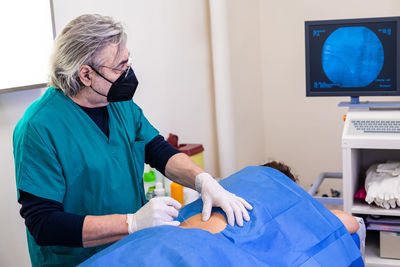 Doctor practices the infiltration of drugs to the patient in the area affected by the pain.