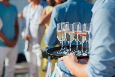 Midsection of man holding wine glass on table