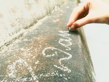 Cropped hand of child writing with chalk