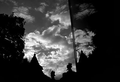 Low angle view of silhouette tree against cloudy sky