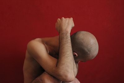 Close-up of man holding hands against wall