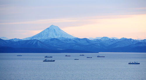 Fishing boats in the bay with the volcano in autumn on kamchatka