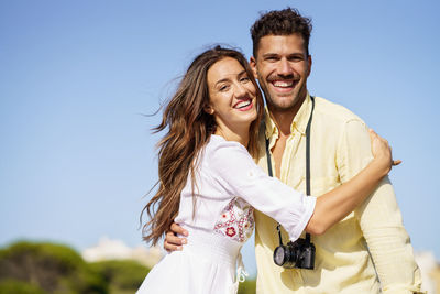 Portrait of smiling couple standing against sky