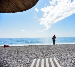 Man standing on beach against sky