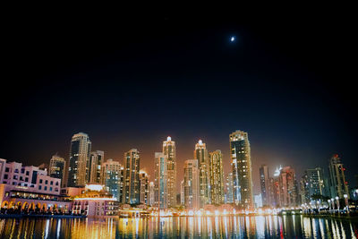 Illuminated buildings against sky at night