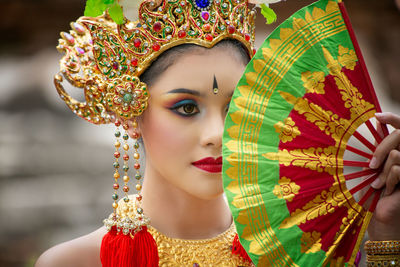 Woman in traditional clothing holding folding fan