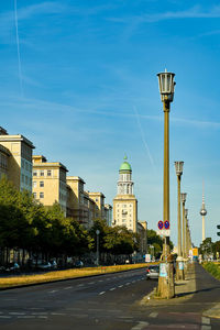 Street amidst buildings against blue sky