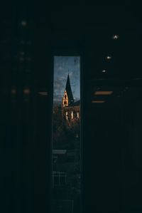 Illuminated building seen through glass window at night