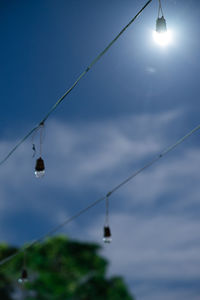Close-up of water drops on rope against sky