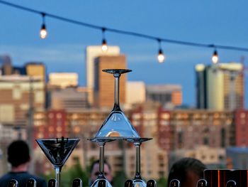 Close-up of martini glasses with city in background