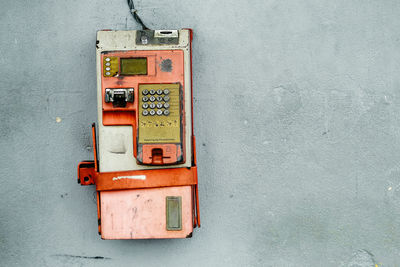 Close-up of abandoned telephone booth on wall