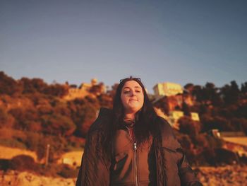 Portrait of urban  young woman standing on land against sky