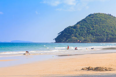 People on beach against sky