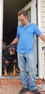 Man with dog standing at doorway