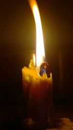 Close-up of lit candle in dark room