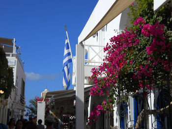 Low angle view of street amidst buildings against clear blue sky