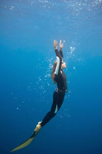 Mid adult woman swimming undersea