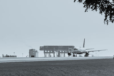 Airplane on runway against clear sky