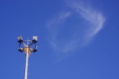 Low angle view of street light against blue sky